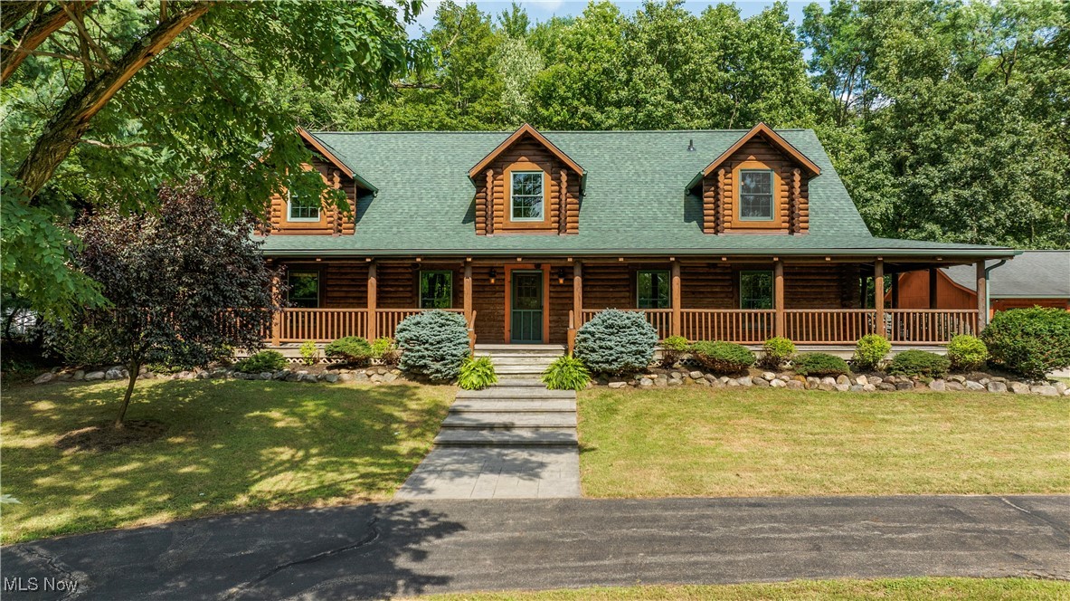 Tucked deep into 3.54 acres of mature woods and overlooking a peaceful ¼-acre pond, this handcrafted full-log home is a dream come true for nature lovers. This rustic beauty home features a 30-year roof (2022) and two stamped concrete entryways leading to a massive 1,679 sq ft wraparound porch—ideal for morning coffee and evenings around the fire pit under the stars. Inside, the great room stuns with cathedral ceilings and massive log beams stretching to the peak. A wood-burning fireplace with a bluestone hearth invites you to warm up after a day in the woods. Wide-plank southern yellow pine floors and tongue-and-groove ceilings echo the natural beauty outside, while solid wood doors add rugged charm. The spacious kitchen is complete with beautiful hickory cabinets, extensive counter space, a 6x4 island, 2025 refrigerator. There’s a walk-in pantry for all your dry goods, a storage closet, and a rustic half-bath with a custom wood vanity. The dining area fits a big farm table for group meals and opens to the back porch and a stamped patio. The oversized laundry/mud room offers a washer 2024/dryer, utility sink, and 11 feet of cabinetry—ideal for post-hike cleanup or gear prep. The first floor newly carpeted owner’s suite is a retreat in itself, with a walk-in closet, private deck access, and a spa-like bath. Head upstairs on the Douglas Fir half-log staircase to a cozy loft and two large carpeted bedrooms—each could easily be a bunk room or second primary suite. The 2nd floor boasts a large full bath. The 1,874 sq ft basement has room for storage, a workshop, gym, or future living space. HVAC 2023, HW tank 2020, Humidifier 2025. Outside, a 40x24 pole barn offers space for 3 vehicles, a full workshop, 220 line, floor drain, 3 overhead doors—ready for your ATVs or tools & 8x16 shed in a fenced in area behind outbuilding. Located just minutes from Medina’s shops and services, but a world away in feel—this is where your off-the-grid dreams meet everyday comfort.