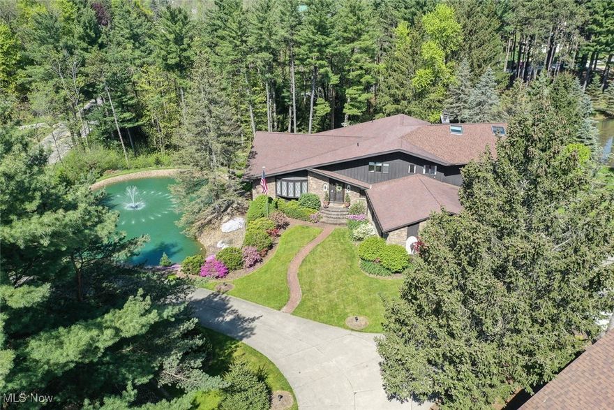 Tucked away on two serene, park-like acres with its own private pond, this custom-built home offers a rare combination of space, comfort, and functionality—inside and out. A 36’x30’ heated outbuilding with electricity provides the perfect space for a workshop, car collection, or creative pursuits. Inside, you’ll find thoughtful updates throughout, including a vaulted living and dining area with a bay window, fresh carpet, and updated paint. The remodeled kitchen features quartz countertops, a generous island with breakfast seating, soft-close cabinetry, and stainless steel appliances, flowing seamlessly into a cozy eating area and screened-in porch for effortless indoor-outdoor living. The adjacent family room showcases a striking stone fireplace flanked by built-ins, plus a wet bar ideal for entertaining. A private study with another fireplace and built-ins leads through French doors to a library retreat. Additional living spaces include a spacious sunroom with deck access and a spiral staircase to a wine room, as well as a large laundry area and half bath on the main floor. Upstairs, the expansive owner’s suite offers its own fireplace, sitting area, private balcony, walk-in closet, and a luxurious en-suite bath with dual vanities. Four more bedrooms and two full baths complete the upper level. The walk-out lower level adds even more versatility, with a recreation space, second kitchen area, full bath, wine room, and access to a covered patio. A private greenhouse adds to the charm of the property, and with easy access to highways and shopping, this one-of-a-kind home truly has it all.