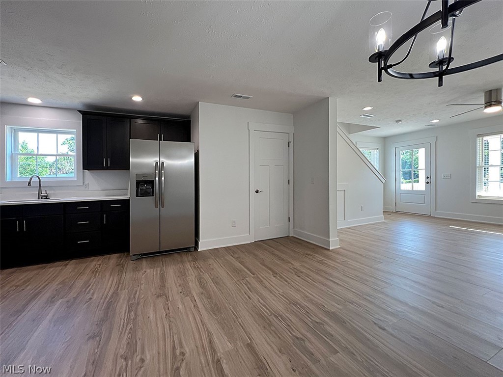 Open concept living room featuring  wood type finished floors, a chandelier, a ceiling fan, and recessed lighting