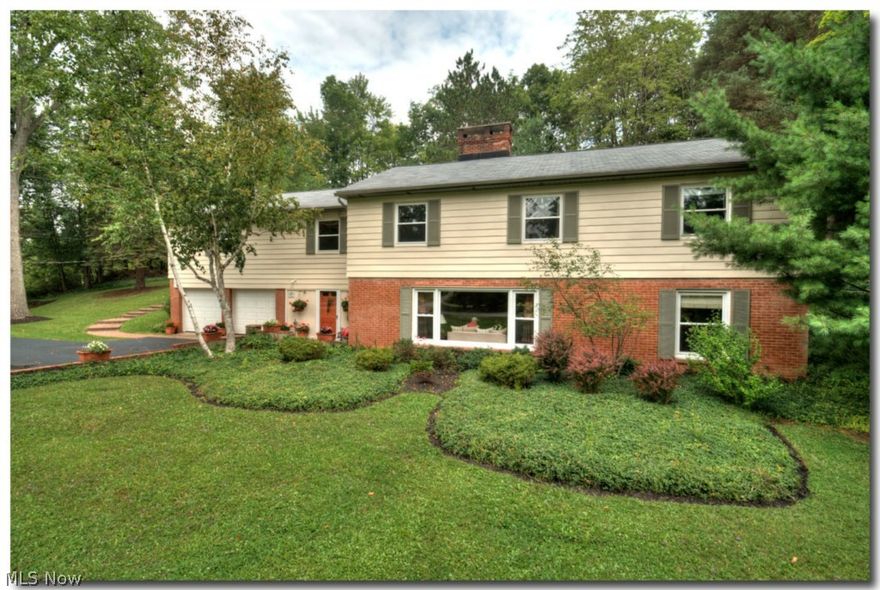 PERFECTION! Walk to town! This 4-bedroom, 3 bath home is in move-in condition! Newer kitchen with granite counters, stainless steel appliances, formal dining area and plenty of storage/counter space. Upper level has master bedroom suite with sitting room and full BA w/marble counters. Two more bedrooms, hall bath, office/TV room off kitchen can be private in-law suite. Lovely living room with wood-burning fireplace complete the upper level. Deck is perfect for private, outdoor relaxation. Lower walk-out level features a full hall bath, 4th bedroom (now being used as an office) and large family room with wood-burning fireplace. Light and bright throughout!  Mint condition!