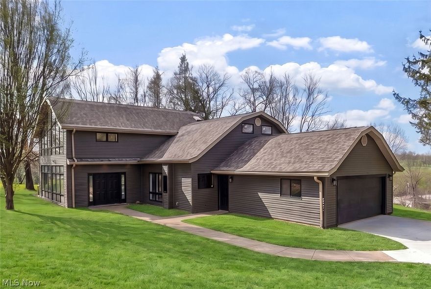 Welcome to a truly exceptional, fully remodeled home offering over 3,100 SqFt of beautifully designed living space on 3.3 acres in the highly desirable East Muskingum School District. Step inside to a grand entryway that opens into a stunning living room, where floor-to-ceiling windows flood the space with natural light and showcase the picturesque views. A wood-burning, floor-to-ceiling stone fireplace adds warmth to the room, while direct access to the side deck creates seamless indoor-outdoor living. Just off the living room, a breathtaking sunroom wrapped in windows offers the perfect space to relax and take in the beauty of the property year-round. The completely remodeled fully applianced kitchen is a showstopper, featuring quartz countertops, a spacious island, abundant cabinetry —perfect for both everyday living and entertaining. The adjacent dining room includes a patio door leading to an expansive deck, ideal for hosting or simply enjoying the sweeping views. The main floor also offers a versatile flex space—perfect for a home office, den, or playroom—along with a convenient half bath, laundry room, and utility room with additional storage. A unique dual-entry staircase adds both character and functionality to the home’s thoughtful layout. Upstairs, the home continues to impress with three spacious bedrooms, including a luxurious primary en-suite featuring vaulted ceilings, a dramatic wall of windows, a walk-in closet, and a spa-like bath complete with a jacuzzi tub, walk-in shower, and dual vanity with granite countertops. A guest en-suite with its own full bath provides comfort and privacy for visitors, while an additional bedroom and full bath complete the upper level. The property also includes a 2-car attached garage, adding everyday convenience to this incredible home. This rare property perfectly blends modern updates, architectural character, and serene acreage, offering the space, style, and setting you’ve been searching for.