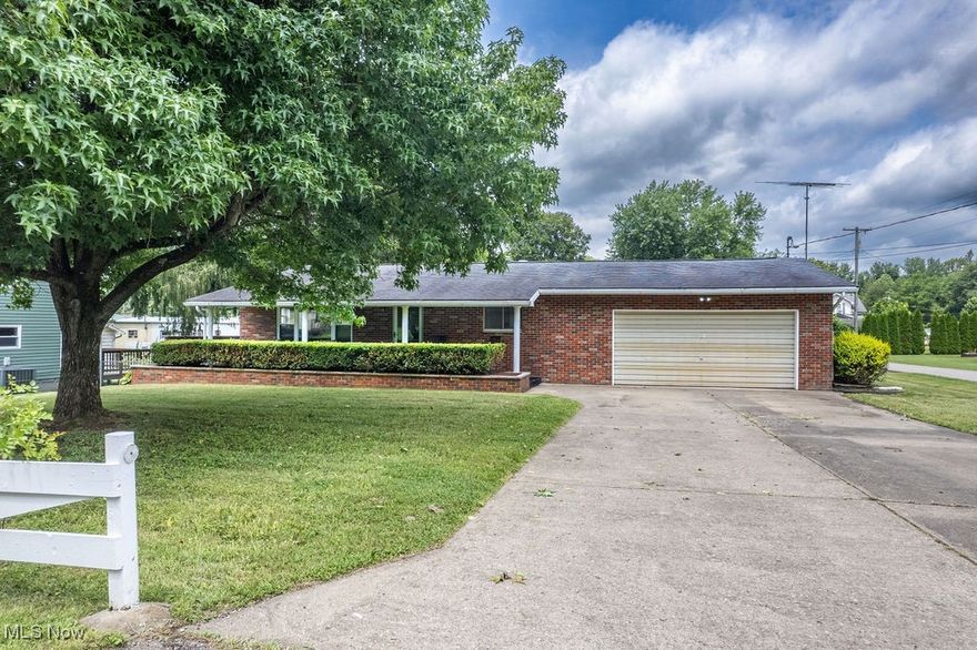 All-brick charm, everyday ease, and backyard bliss come together in this thoughtfully laid-out ranch on a spacious corner lot. Wrapped in a white picket-style fence with blooming mini and full-size rose bushes lining the front, the curb appeal sets the tone before you even step inside.

A 3/4 wraparound porch flows effortlessly from the covered front entry to the expansive side and back decks, offering the perfect blend of charm and function. Whether you’re sipping morning coffee, entertaining friends, or enjoying quiet evenings, the outdoor space invites year-round relaxation. Just beyond the deck, the above-ground pool offers a refreshing retreat, while the fully fenced backyard provides privacy, multiple gate access points, and space for play, pets, or gardening. A large outbuilding with electricity is ideal for hobbies, storage, or a workshop, and an RV parking pad with 30/50 amp electric adds even more versatility.

Inside, the living room welcomes you with a generous picture window that fills the space with natural light. Off the hallway, a spacious walk-in closet provides excellent storage, and both bedrooms feature their own large walk-in closets for a peaceful and organized retreat. The full bath is generously sized and centrally located.

The eat-in kitchen offers a warm, functional layout with stainless steel appliances, wood-look cabinetry, and plenty of counter space. A hallway off the kitchen leads to the laundry area with a convenient closet pantry and direct access to the back deck—making outdoor dining and daily chores a breeze. The oversized double garage is also accessible from the kitchen, providing storage and workspace beyond just vehicle parking.

With a layout designed for easy living and a property filled with character, comfort, and space to stretch out, this brick ranch is ready to welcome you home.