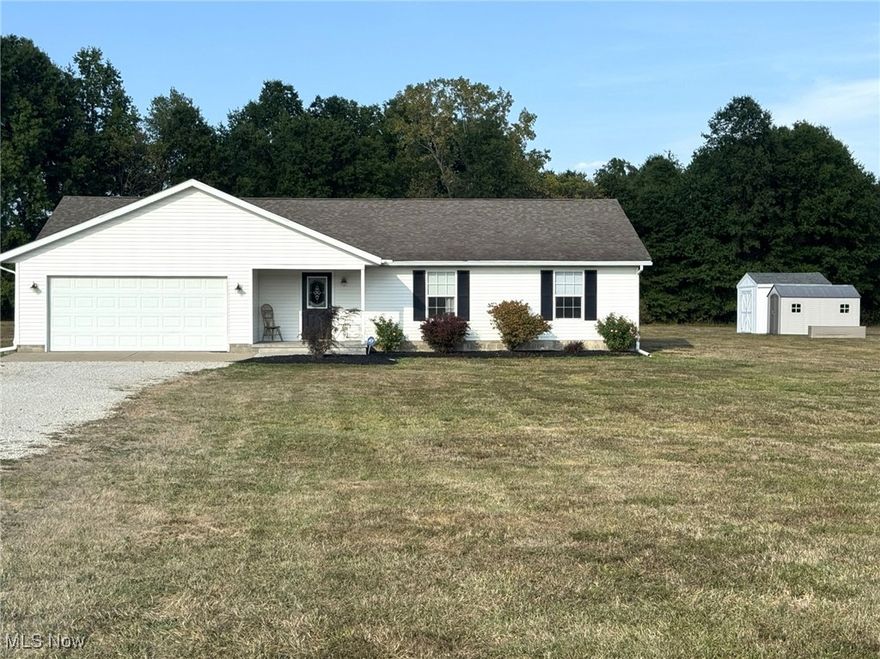 Effortless Living on 3.561 Acres of Peaceful Beauty
If you’ve been searching for a low-maintenance, move-in-ready retreat, this charming home delivers. Nestled on over 3.5 acres of open land with a wooded backdrop, the property offers both space and serenity. A stamped concrete front porch welcomes you into a spacious foyer, opening into a bright, airy layout that seamlessly connects the living room, dining area, and oversized kitchen. Step out onto the back patio and take in the tranquil view—complete with two storage sheds and your own private shooting range.
Inside, you’ll find two full bathrooms featuring granite countertops, including an en-suite off the primary bedroom. The main suite also boasts a generous walk-in closet. Thoughtful details like a hallway laundry nook with a sliding barn door and abundant storage throughout make everyday living a breeze. Though built on a slab, this home is impressively organized and spacious.
Extras include all major appliances—washer, dryer, refrigerator, stove, and dishwasher—plus a heated garage for year-round comfort. Some furniture may be negotiable.  Handy location on SR 14, close to NEOMED and I 76.  Property is in Edinburg Township with Southeast schools.  Immaculately maintained and sparkling clean, this home is ready for you to move in and enjoy.