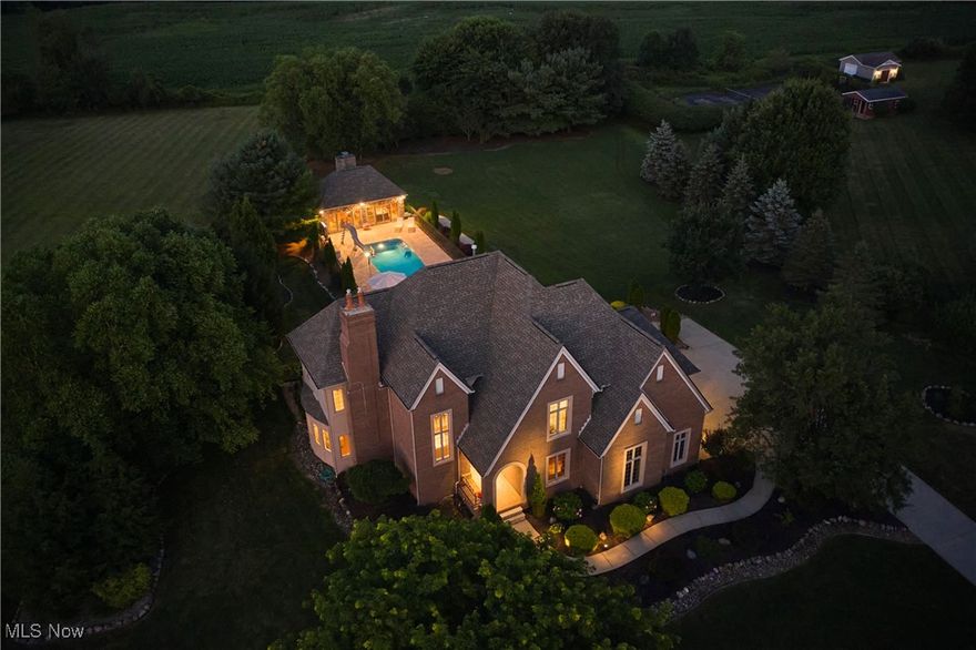 This stately home offers a rare opportunity to enjoy a life of comfort, privacy & connection to the outdoors. Set on approximately 2 private acres in Highland Local Schools on a cul-de-sac street in Wolf Creek Estates.The standout backyard, designed for both relaxation & entertainment, features an in-ground heated pool, 432-sq-ft pool house w/ A/C & heat, 2-level stamped concrete patios w/ built-in grill & bar seating, firepit table & a scenic backdrop of open land with no rear neighbors. Inside, over 3,874 living sq ft blends timeless architecture w/ flexible living. A 2-story foyer opens to elegant spaces w/ hardwood flooring, crown molding & wainscoting. A formal dining room features a double-sided fireplace, shared with a family room, and flows into a light-filled living room w/ a 2nd fireplace, wet bar & wall of windows overlooking the backyard. A 1st-floor office is rich w/ built-ins & detailed trim. An eat-in kitchen is warm and functional, w/ granite countertops, stainless steel appliances, center island & a bright dining area w/ built-in breakfast bar surrounded by windows. A 1st-floor laundry room adds convenience. The owner’s suite includes a tray ceiling, 4th fireplace, dual walk-in closets, and spa-like en-suite bath w/ tiled walk-in shower, jetted tub & double vanity. Two additional bedrooms share a Jack-and-Jill bath w/ separate vanity areas. The 4th bedroom guest suite features its own full bath & generous closet space. The pool house extends the home’s comfort & charm w/ a vaulted beamed ceiling, wood-burning fireplace, half bath & built-in drink cooler, perfect for year-round entertaining. Additional features include a BRAND NEW ROOF, rough-in plumbing for a full bath in the basement, attached 3-car garage & a rear outbuilding w/ overhead door. Nestled in a quiet neighborhood surrounded by nature & wildlife, Wolf Creek Estates also offers a community green space across the street w/ pond access for fishing and recreation.