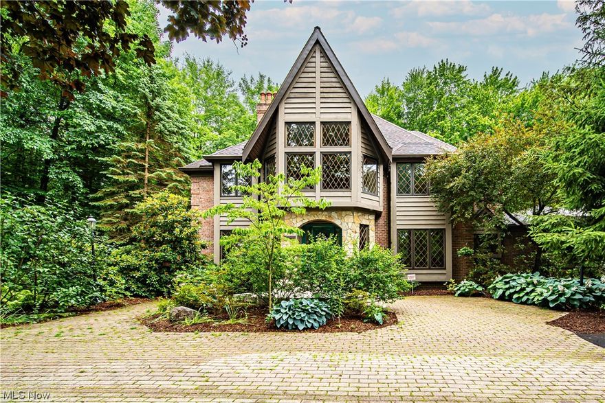 Elegant country feel welcomes you into this lushly landscaped home. Sitting on 2.6 acres with a circular driveway. The brick drive entry welcomes you into a grand two story foyer with a circular staircase. Upon entry is a cozy living room with a fireplace. On the opposite side are french doors leading to a formal dining room. The fabulous great room attracts you to the coffered ceiling and fine millwork. The stone fireplace is surrounded by built- in bookshelves and floor to ceiling windows that will captivate you while viewing the changing seasons. A private library/office with the 3rd fireplace is found off the great room along with a delightful sunroom leading to a brick patio. The kitchen is sure to please with granite countertop, SS appliances, double oven with dutch door. wine fridge and a beautiful breakfast nook with access to outdoors. A spacious powder room and laundry room are also found on the main floor. The 2nd floor loft with a wall of windows allows the light in along w