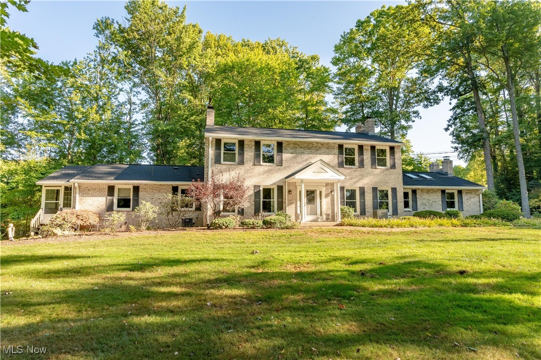 Tucked away in the desirable Jackson Local School District, this all brick Colonial offers 3,694 square feet of living space on a beautifully landscaped 4.27 acre private, wooded lot. The spacious layout includes five bedrooms and 4.5 baths. Original in-law suite could now serve as a first floor primary suite; featuring two full bathrooms, a laundry area, ample closet space, and access to a private porch. The home is filled with natural light, highlighted by a large Great Room with a gas fireplace, and eat-in kitchen that opens to a screened-in porch with nature stone flooring - ideal for entertaining on quiet mornings. Additional main floor spaces include a formal living room with a second gas fireplace, a large office, several rooms offer elegant coffered ceilings. Upstairs, four generously sized bedrooms offer plenty of closet space, including one with its own fireplace. The full, unfinished basement includes multiple storage rooms and endless potential for recreation, hobbies, or a home gym. A rare feature, the home includes an attached heated four car garage with a sauna, water hookup, and floor drain. There is also a detached five car garage - perfect for car collectors or workshop needs. Updates include a 2024 roof, replacement windows throughout, and a whole house generator. This exceptional property combines privacy, space, and unmatched functionality - a truly rare opportunity in Jackson Township.