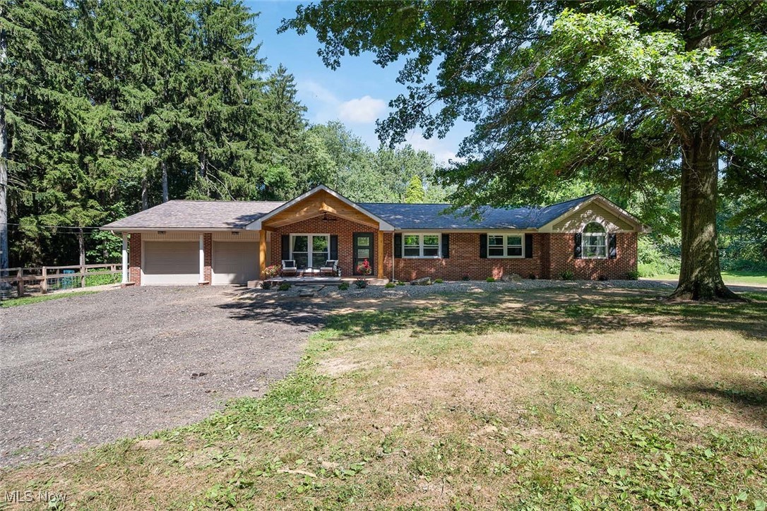 This sprawling brick ranch sits tucked away in a private setting on 5.68 acres in the Tuslaw Local School District. Nicknamed "The Peaceful Pines" for its mature trees and storybook setting. This beautifully updated home features an inviting front porch with views of the incredible yard and fresh landscaping. The foyer entry leads you to a private office with French doors. Just down the hall, the great room features an open concept, gourmet kitchen, family room with wood-burning fireplace, and new sliding doors that lead you to an expansive, multi-level composite deck. Spacious, main-floor laundry room with updated full bathroom. The primary bedroom features a spa-like bathroom with a tile surround shower and claw-foot tub, along with an expansive walk-in closet, and access to the new deck. Two additional bedrooms share an updated full bathroom - an ideal floor plan! Additional updates include all new windows, exterior doors, lighting, gutters, downspouts, furnace, hot water heater, and many more - making this home truly move-in ready. The property also includes a 30'x45' pole building with a heated, above-ground, saltwater pool and extra storage space. A one-of-a-kind property! Call today for a private showing!