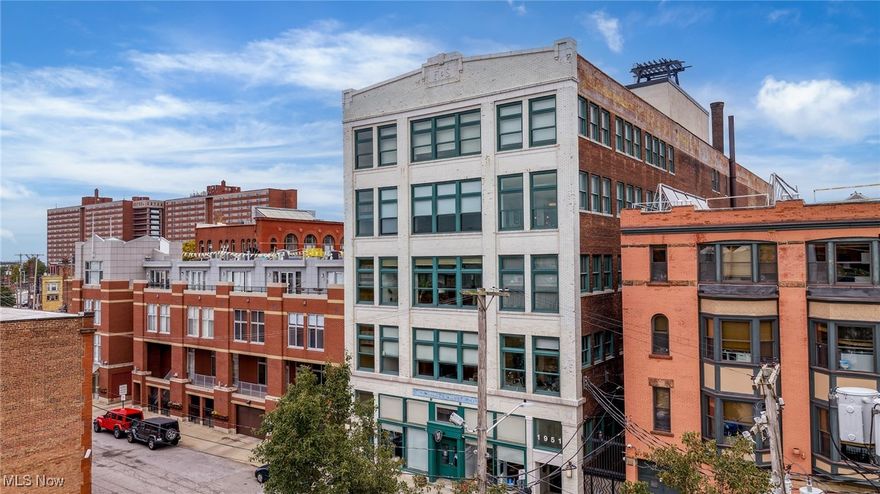 Incredible Top-Floor Skyline View Condo in the Iconic Fries & Schuele building! This 2-bedroom, 2-bath condominium offers one of the largest floorplans in the historic landmark building and comes with the luxury of TWO deeded, attached, covered parking spaces. Step inside and be immediately captivated by the soaring great-room ceilings, original 19th-century hardwood floors, exposed ductwork, and oversized windows that flood the space with natural light while framing UNBEATABLE views of downtown Cleveland and bustling West 25th Street. The updated kitchen blends historic character with modern style, featuring sleek stainless steel appliances, granite counters, a bar for seating, and a glass tile backsplash set against rich maple cabinetry. The spacious primary suite includes a walk-in closet and full bath, while the second bedroom and bath provide flexibility for guests or a home office. A convenient side-by-side washer/dryer is tucked away near the entry, complemented by abundant in-unit storage plus a dedicated, secure storage space in the lower level. Residents enjoy a worry-free lifestyle with amenities that include a private courtyard, 24-hour fitness center and inviting lobby. Just outside your door is Market Square, home to some of the city’s best dining, breweries, and the iconic West Side Market. Located only 5 minutes from Downtown Cleveland and 15 minutes from the Cleveland Clinic and University Circle, this property perfectly balances history, style, and convenience.