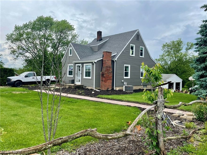 This extremely cute bungalow with a gorgeous backyard and private patio is must see!  If you are looking for some land to create your own oasis, this property is for you!  So many updates already done in recent years including new vinyl siding and roof, newer hot water tank and Carrier furnace, insulation in attic and attached garage, waterproofed basement, and sump pump with a battery back up!  New laminate flooring in the living room and re-stained original hardwood upstairs.  Two spacious bedrooms on the first floor and two on the second floor, with a bonus room for storage upstairs too.  Newly updated full bathroom with tub and shower and new exhaust fan on the main level and half bath with a shower and toilet off the finished area in the lower level.  The walk-out lower level has a finished office that could also be used as a 5th bedroom. 200 amp service.  Hard wired smoke alarms.  Ringed Door bell and camera system at each entrance. Ductwork professionally cleaned in May 2024. The beautiful backyard has several garden areas, a large deck and patio with a fire pit area, a walking trail in the woods as well as a secluded camping site at the back of the lot.  So much potential to make this house your own, just needs some finishing touches! Selling As-Is.  Stark County Well and Septic point of sale inspection is complete.