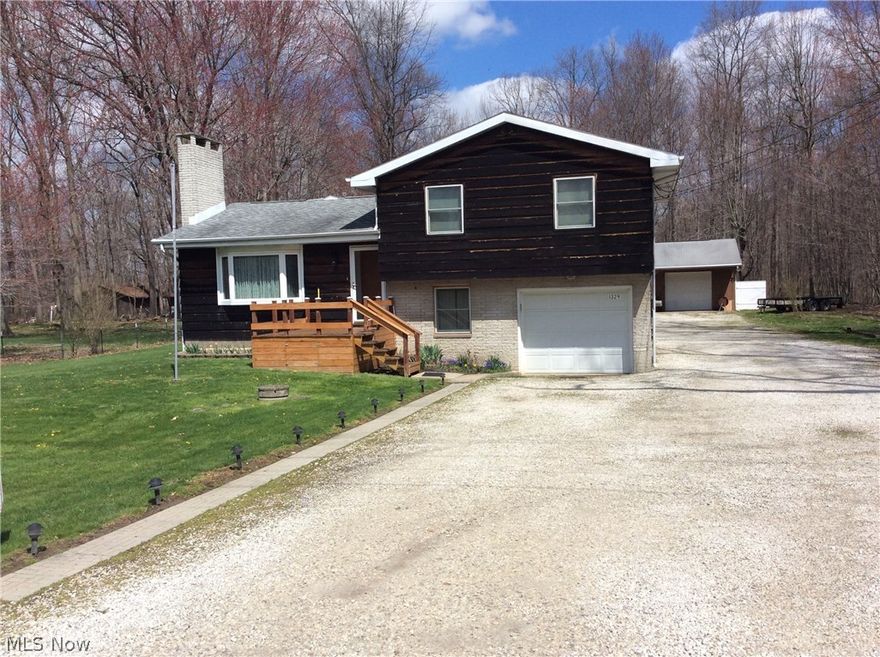Welcome Home to this lovely well built split level. Cathedral ceiling in open floor plan of living room and dining room, beautiful hardwood floor, fireplace, bayed window, all this open in newer addition Family room with ceiling fan, hardwood floors that also leads to great outdoors. Upstairs is 3 bedrooms with plenty of storage and full bath with Jacuzzi tub. Lower level included a recreation room with wood burning stove, tons of shelving for all your storage need in the laundry room, sitting room with 1/2 bath greets you as you come in from the garage. Car bluff need to see the 32x40 heated garages with a man cave attached, bring all your toys with you. Close to everything and can be to Akron/Canton with minutes.