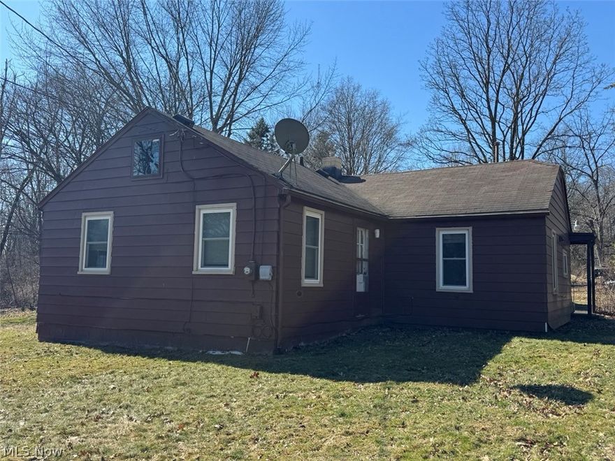 Country in the city! Enjoy this peaceful one acre wooded location off the beaten path.  This large corner lot offers multiple ingress/egress from two streets. Nice open floor plan with kitchen open to the living area. First floor laundry is in the closet of one of the bedrooms. The second bedroom has an attached room with an exterior door that would make a great office to allow people entry without coming through the house. Or it would make a lovely nursery or large walk-in closet. Some cosmetic improvements are needed but the house is in great condition. The original kitchen offers ample cabinetry and a portable/movable island. There are three permanent outbuildings. There is a heated and insulated shed with access on both ends. There's a 1.5 car garage with overhead door and separate workshop/storage area at the rear. The third building is another shed. There is one temporary building that should be removed.