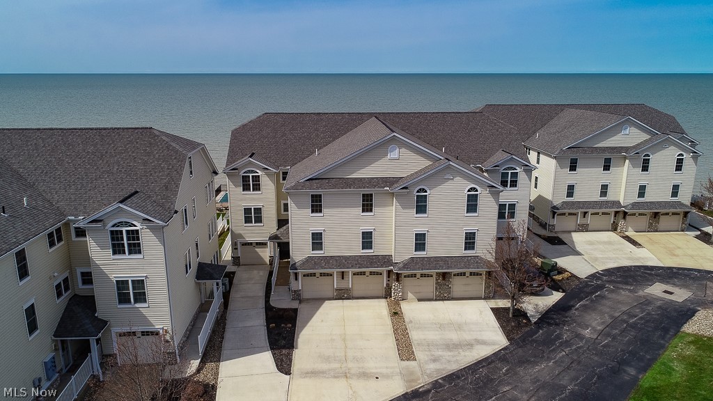 Lakefront living at its best! This impeccable rare 1st floor two story condo has 360 degree views of Lake Erie from the great room, owners suite & sun room! The lower recreation level walkout has equal views of lake & pool just steps away! The main level has open concept kitchen with bar counter, maple cabinets, granite counters, pantry & newer appliances. Great Room with vented gas fireplace & patio doors out to a deck for watching summer sunsets! There are french doors to a sunroom/office with two walls of windows for a spectacular view of the lake. This level offers the relaxing owners suite with walk-in closet, built-ins, ensuite with double sinks, tile floor, shower & soaking tub. There is another full bath w/tile flooring, bedroom & extra large laundry room w/sink and storage that completes this level. There is a mix of wood laminate flooring as well as carpet. Lower level boasts an extra large recreation room, plumbed for gas fireplace, double patio doors out to patio, pool & s