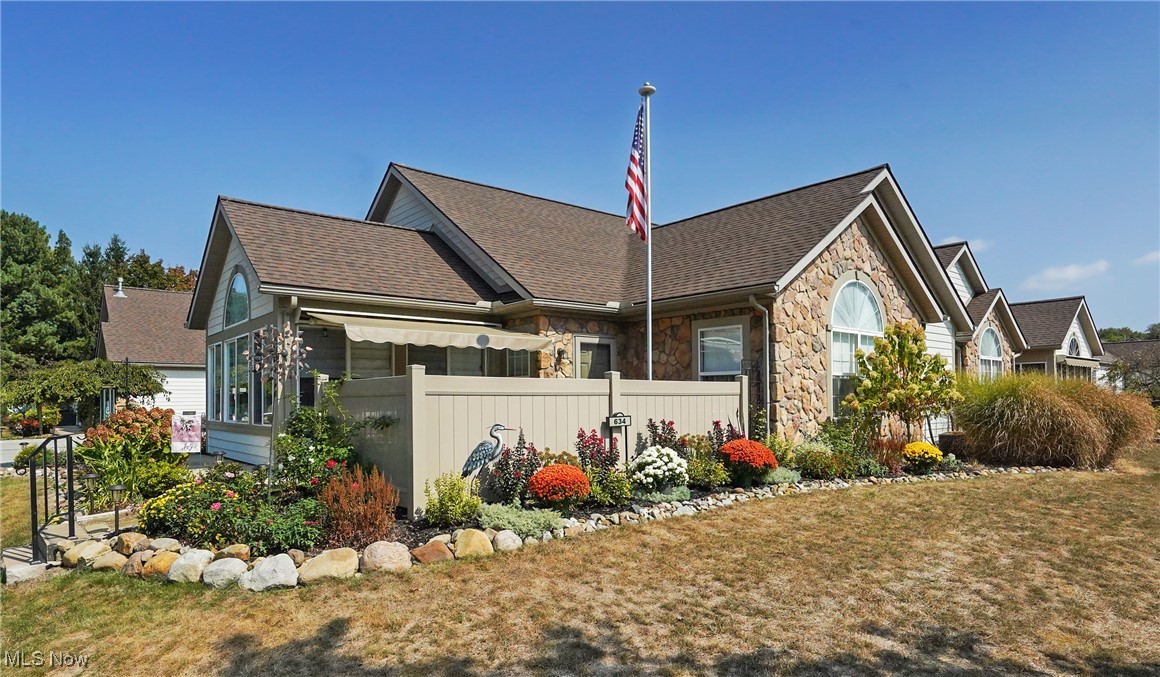 Welcome to 634 Crossings Circle! This lovely condo sits on one of the nicest lots in the development! The professional landscaping provides beauty and color, and this end unit has a wooded view. The large patio is adorned with flowers, a Sunsetter retractable awning a flagstone garden path, and a 4 ft vinyl privacy fence installed in 2024. Outdoor living at it's best! Inside, the modern open floor plan 2 bed/2bath condo is light and bright with a custom stone fireplace and vaulted ceilings throughout. The owners have taken immaculate care of this condo and there's nothing to do- updates have already been done! Tasteful LVT is throughout. The kitchen features granite countertops and newer black stainless steel appliances and an extra cabinet that stays. Both bedrooms are spacious with the primary having an attached bath and walk-in closet (the second bedroom also has a walk-in closet). The large sunroom with glass French doors brings the outside in for year round enjoyment and has custom Roman blinds. The Crossings at Northwest has fabulous amenities and is an enjoyable community to live in. The clubhouse features a party room (regular events are held throughout the year), that can also be rented out by the residents. A well-appointed fitness room and library are also in the clubhouse. During the summer you will love using the crystal clear heated pool and patio area. Additional updates include newer washer and dryer, entry door, solar fence lights, and wood storage shelves in attic. Roof was replaced in 2025, and exterior painting and replacement of wood siding and trim in 2024. 1 year Home Warranty provided for your piece of mind. Schedule your showing today!