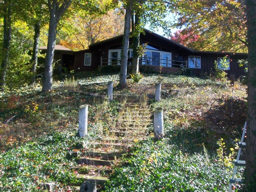 Amazing Opportunity in Roaming Shores! 3.15 lakefront acres on the widest part of the lake. Fantastic, panoramic views; sunsets; privacy; mature trees; lots of ivy; long drive; and slopes nicely to water. This sale comprises 2 lakfront lots with a house on one of them. Could be separated and sold as 1 vacant lot, and one lafront property with home. Home is ranch style with 3 brs, master bath and additional bath, vaulted wood ceilings with wood beams, great stone FP with wood stove insert and very nice mantle, and superb view and access to the lake. One of a kind! Easily one of the top 2 lots in Roaming Shores. Premier location!