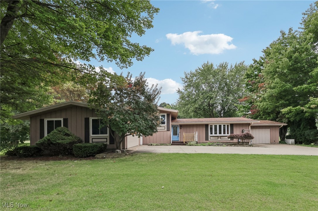 What a spectacular family home! So much space inside and out. The eat in kitchen offers Kraftmaid cabinetry, granite countertops and garden doors leading out to the huge patio. The pergola helps keep it cooler during the warm days. The formal living room is on the main floor with the multi purpose family room on the lower level. It has a custom made bar with many build-ins, a cozy corner office and an expansive area for hanging out to watch movies, have get togethers or simply relax after a long day. With 4 bedrooms, the master is an on suite and offers privacy. The basement of the home is where the new furnace with central air, new water heater new electrical box and electrical box for new whole house generator are located. The 2 car garage is attached and there is a single car garage attached on the other end of the home that has been made into a 2-3 season room. The garage door with opener is still in working order if it needs to be converted back. All of this house...this space for a large family sitting on over 5 acres of land. A few of the acres are wooded. The outbuilding is 24 x 24 with a full 2nd story, 220 electric service and cement floor. She's a beauty!