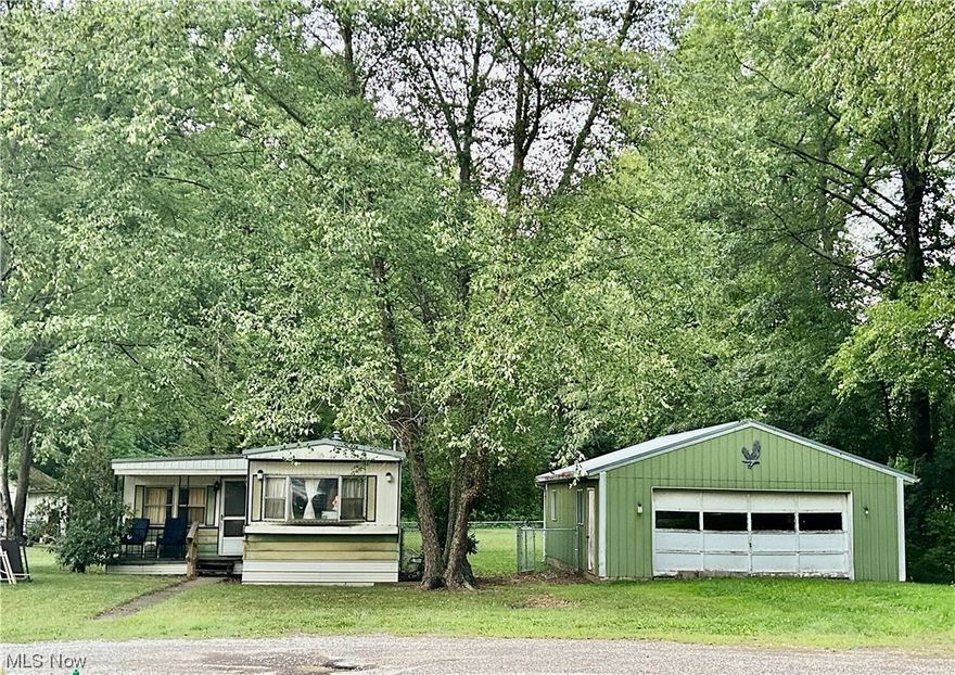 Spacious mobile home with 3 bedrooms, 1 full bath, laundry, situated on a double lot with a 2 car detached garage. Newer metal roof on the mobile home and garage.  Garage is 24 x 32. Public water and sewer and natural gas heat. Nice and private location.