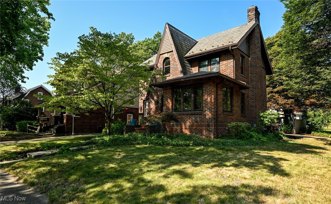 Located in the heart of the historic Firestone Park, this stately home has retained so much of it's original architecture. Iconic style, dark red brick, sharp gable w/ an arched window & front door, topped w/ a classic slate roof. Situated on a large corner lot, w/ mature trees, an attached 2 car garage & a fenced in private back yard. Step in through the original arched front door into the most charming entry. Inside you will be in awe of the beautiful hardwood floors, original swinging doors & handsome original woodwork that runs throughout the entire home! The massive living room features wall sconce lighting, a tile flanked fire place & leads to glowing sunroom. This spot is amazing as a reading room, home office, play space for the kids or exercise space. The formal dining room is just perfect & has a swinging door into the kitchen. A breakfast nook area w/ built-in china cabinet, opens to the main kitchen, w/ plentiful storage & a large pantry! Around the corner is the attached garage, a wonderful half bath, stairs to the basement & door out to the driveway. Up to the second level is a fantastic open hallway leading to another bathroom & all 3 bedrooms. You will adore this bathroom, w/ the perfect mix of old & new! Original archways, wall tile, tub & built-in linen closet, matched w/ modern glass/marble mosaic wall tile & lighting. Tons of great space & the most adorable nook w/ double closets & an arched window complete the master bedroom. The 2 additional bedrooms are very spacious as well. Be sure to take a peek up to the walk-up attic. This space is begging to be finished off to make a 4th bedroom or bonus room! There's still a solid full basement w/ an updated electric panel, laundry area, built-in kennel & all the storage space you could need! Back outside is the awesome back yard highlighted by some unique artistic features & great patio/ firepit gathering spot! You DO NOT want to miss out on this home so CALL TODAY!