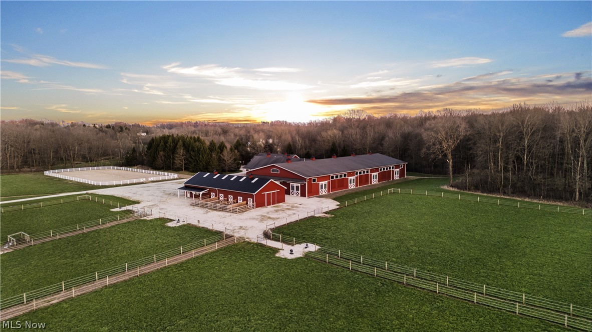 Meadow Creek Ranch presents an unparalleled opportunity to own a state of the art 19 stall horse facility with an indoor 200 x 83” heated riding arena and a custom built Farmhouse. Situated on over 85 pristine acres in Mantua, Ohio, this incredible Ranch is well equipped with 2 large Barns amassing a combined total of 19 stalls and built by renowned Morton Builders. High end features of these heated barns include a Nelson watering system in each stall, with limestone screening and rubber mats, interior sliding stall doors, and individual dutch doors to the exterior fenced in spaces for each stall. In addition to the indoor arena with new lighting and sliding doors to the side pastures, the main barn boasts a spacious tack room, a viewing room, and a bathroom for guests. Between both barns there are wash bays and 3 all weather stalls for horses that can't be pastured. 8 pastures on 15 acres with Nelson watering systems on 4 of them and 2 with 8x 16 runs that match the barns, provide ample outdoor grazing space. There is also a 200’ X 100’ fenced-in outdoor arena, 2400 sqft shop barn to store tractors/tools and for your riding pleasure, multiple horse trails in the woods to explore. If all of that is not exciting enough, the hay pastures produce 2500-3000 bales of hay a year, offsetting the cost to buy hay. The cherry on top is the gorgeous and well designed farmhouse built in 2005 with custom reclaimed wood, copper gutters, soaring ceilings in every room, a stunning kitchen with charming finishes, a butler's pantry, 4 large bedrooms, all with en suite baths, and 3 fireplaces complete with custom millwork. The detached 3 car garage also hosts a loft apartment complete with a kitchen, living space and high end full bath! Just a short drive from Akron, Kent, and Chagrin Falls, it's the perfect set up for any horse enthusiast. An equestrian's dream property, this gem is not to be missed!