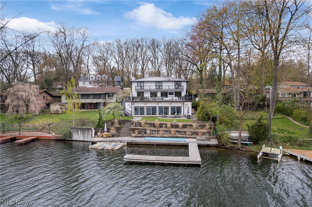 Luxurious Lake front, East Reservoir, Portage Lakes with million dollar views! Ultimate functionality & beautifully remodeled 2017-2021* Open floor plan, 4 BD/3.5 BA, w/a total of 5134SF * High end finishes & features including heated indoor pool* 1st level wood floor* WBFRPL w/gas starter* Chefs kitchen having quartz counters, large island, stainless Thermador appliances (refrigerator, 6 burner gas top, double oven, microwave, dishwasher), pot filler over range, soft close close cabinets, pantry & access to expansive lakeside composite deck (approx. 32x44)* Deck includes speakers, TV, 6x12 table & chairs & steps to Lake* 1st floor also incl. half bath, laundry w/sink, quartz, laundry chute from 2nd floor, abundance of cupboards & back entrance coat nook* 2nd level owner's suite w/access to composite balcony, walk-in closet w/built ins, granite double vanity, modern soaking tub, oversized tile shower having 3 shower heads & heated floor* 3 add'l bedrooms (2 w/access to balcony) & guest bath w/granite double vanity & tile shower complete the 2nd floor* Walkout lower level…family room w/electric FRPL, TV, full wet bar w/quartz countertop, dishwasher, ice maker, 2 beverage refrig, & soft close cabinets….Opens to 12x4 wine room which holds 990 bottles & includes humidistat for proper cooling* Walkout also includes full bath w/quartz counter, heat lamp & an M-Finn sauna* LVT throughout lower level ideal for entertaining especially with the pool, full window view of indoor heated pool (15x36), new tile around pool, dry bar & 4 sliding doors giving view & access to paver patio with fire pit & steps to Lake* 70' of lakefront, concrete sea wall, plenty of room for water toys & dock that can hold 3-4 boats* Separate furnace for pool in pool equipment room)* Pretty landscaping w/path lighting in front and back* Brick ext.* 2+ car garage & plenty of parking* Water softener* Security system* Front yard fenced with security gate* Home warranty provided incl. pool* Beautiful!!