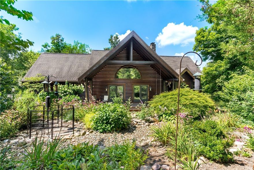 Meticulously maintained and updated, 3 bedroom (large game room could be converted to 4th bedroom) 2.5 bath log cabin sits on 4+ acres. Exquisite Country Retreat in Granger Township within the Highland School system. Acres of greenery with rolling terrain, streams and ravines. Vehicle and pedestrian bridges are perfect for the outdoor hiker or ATV enthusiast.  A 10x13 storage shed, 1.5 story 20x24 barn with 8x24 carport provides plenty of storage. Back yard also features a custom chicken coop with run, fenced and raised vegetable beds with perennial landscaping.  The Koi pond with waterfall visible from the large, covered front porch. A newly-built, 620sf Trex deck with aluminum & cable rails topped with hardwired post lights. The first floor Master suite has a remodeled Master bath with walk-in closets; tiled, custom walk-in shower with dual shower heads and quartz bench; and custom double sink vanity with quartz counter.  Master bedroom has large vaulted ceilings, stone-faced gas fireplace and spiral staircase with a private loft.
Living room has floor to ceiling wood burning fireplace and large arched picture window. Dining/kitchen area has granite countertops and stainless steel appliances. Upstairs has large game room with pool table, a full bath and two bedrooms.  The walk-out basement with laundry has ample storage. Nearly everything updated and upgraded: remodeled 1/2 bath to light fixtures/ceiling fans being upgraded and every room repainted.  NatureStone garage flooring in the attached oversized 2-car garage; new carpet throughout the upstairs and loft 2022; new electrical panel/wiring to code 2022; new Carrier furnace 2023; Radon system; new water softener and iron filter with RODI kitchen faucet filtration system; new septic aerator in 2025; Ring camera floodlights and a Ring camera doorbell; Ambient Weather Station on roof with monitor read-out in kitchen; log exterior professionally re-stained August 2025. Enjoy turn-key, serene country living!