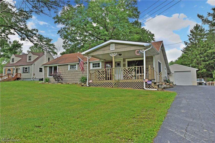 Don’t sleep on this cozy ranch home! With welcoming rooms, a massive detached garage, and a covered outdoor bar area; this residence will be quickly filled. A long blacktop drive features a turnaround while leading up to one of two patio areas. An additional covered front porch makes for scenic relaxation, while the poured concrete rear bar area ensures room for both storage and entertaining. Newer siding covers the outside of the home for clean appearance. Inside, hardwood style flooring fills the lower stepped level as a family room shares the floor with small office space. Laundry service resides in a room nearby. Through a raised doorway, a massive, carpeted living room provides plenty of comfortable living space. The main hall contains two ample bedrooms, each with mirrored closets. Tiled flooring begins at the kitchen to reveal real wood cabinets and glass tiled walls. Stainless appliances add a modern touch as you dine before a large double window. Around the corner, a spacious