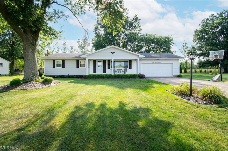 Quiet 3 bedroom, 1.5bath ranch in Columbiana nestled on a half acre. Entering the property on the covered front porch, you are greeted by a nicely sized living room with natural hardwood floors that carry through the eat-in kitchen and into all of the bedrooms. Ample cupboard and counter top space in the kitchen; cooktop, built in microwave, wall mounted stove, dishwasher, and refrigerator are included in the sale. Enjoy additional finished square footage with a functioning wood burning stove in the basement. Excellent view of the wooded back yard from the enclosed sun porch off the back of the home. Low maintenance landscaping with modern black stone, nicely pruned shrubs, and matured trees for a nice shady retreat. Plenty of storage in the attached 2 car garage as well as an attached storage shed.  Energy efficient double hung vinyl windows for easy cleaning. Washer and dryer also included. A One Year Home Warranty is being provided for additional coverage.