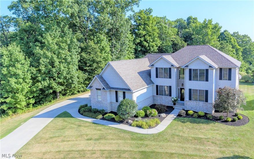Exceptional. Incomparable. This custom-design home with additional in-law suite (multi-generational suite) is warm, welcoming, and one-of-a-kind.  This home is located in a secluded development proximate the Cuyahoga Valley National Park and close to everything. The design features a largely open floorplan with generously sized first floor in-law suite and a second kitchen. Formal living and dining rooms offer bright light and neutral décor. Highlights of this wonderful home include: two-story great room with full two-story windows overlooking picturesque views of wooded lot; custom design gas fireplace; marble countertop island; two full master suites; jacuzzi tub; walk-in closets; large second floor bonus room; full basement; large laundry room with custom cabinetry; three-car garage; and professional-design mature landscaping. Excitement surrounds the potential for adding additional square footage by finishing the full course basement. Hidden gem location on a private cul-de-sac roa