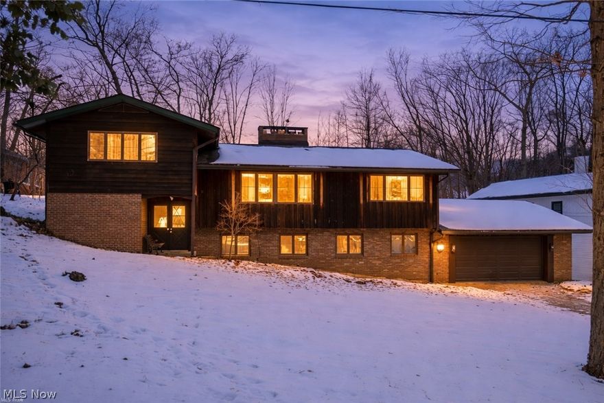 Set in Turkeyfoot Heights with community park, beach, and lake privileges for residents, 3812 N Glenridge Rd offers space, flexibility, and quick proximity to Portage Lakes for summer fun. A standout feature is the first-floor primary bedroom with a full ensuite bath, making daily living easy and comfortable. The dining room slider opens to a brand-new deck (2025), and the nearly half-acre lot includes a shed and room to garden, play, or unwind outdoors. Hardwood floors run through the living room and all four bedrooms (under carpet in one room), while vaulted ceilings add volume in the living room, kitchen, dining room, and primary suite. Gather around the see-through fireplace connecting the family room and dining room, plus additional fireplace in the study/library for cozy nights in. The kitchen features skylights added in 2022 and a built-in brick grill, and the home delivers bonus space with a dedicated office, a library with floor-to-ceiling shelves, a large living room with walk out to back yard, as well as a walk-out laundry room, and two finished lower-level bonus rooms for hobbies, media, or guests. Big updates include a new roof (2022) and updated 200-amp electrical service (2022). An oversized attached 2-car garage, gas heat, and public sewer round out the essentials, along with a low annual HOA of $200 that supports the community park and resident lake/beach access. The association also offers boating, social and gardening clubs, and holiday events at the park, adding even more ways to enjoy the neighborhood year-round.