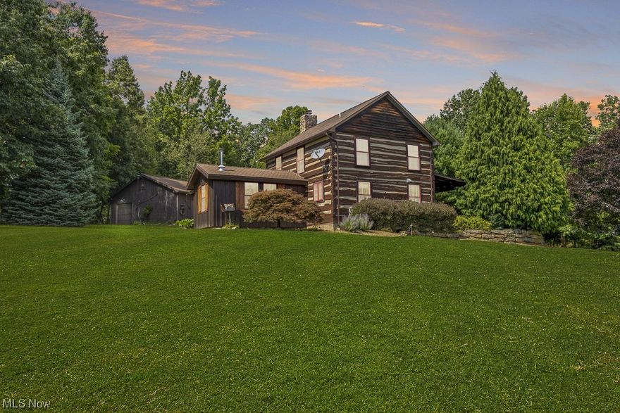 This Country Road...will Take You Home!  This amazing log home is move in ready, just bring your own dog!  The wood was re stained and treated in the last 5 years.  The well is 300+ feet deep and no softener is needed.  There is a carbon Conditioner.  In addition to the fireplace in the living room there is a wood burning stove in the dining room, and a wood burning furnace in the Garage.   The natural beauty of the 12.65 acre lot is breathtaking.  The large 6 bay garage is currently being used as a 3 car garage and an office, work space.  There is an additional 20x24 custom built barn with a walk up loft.  (see photos)  There is an additional .977 parcel, 9741 Waynebridge Rd. that has a 2 car garage built in 1986 and a barn that was built in 1990.  The trailer that was on the lot has been removed.  Did I mention the fruit trees, berry bushes, the fire pit, the raised bed fenced garden, tool shed, and the Chicken coup and wood storage that holds enough wood to keep you cozy no matter w