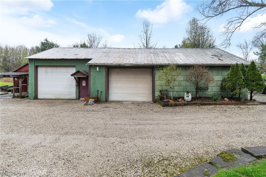 6+ acre parcel has space for 5+ cars or oversized vehicles, zoned B1 in city of Green. The XL garage, pole barn, 2 sheds, a pond and 3 bed 2 bath home holds possibilities! The workshop garage has Airtite Liftmaster 10,000lbs., an electric hoist, air compressor system w/2 tanks, electric throughout, floor drains, wood burning furnaces, exhaust, insulated ceilings, and lighting like an operating room! Office building is 15x9, has electric baseboard heat and power outlets throughout. Pole barn is 24x14 plus a carport & has its own electric. Other outbuildings include 2 sheds, a small storage barn, and greenhouse. On the property there is crushed gravel that can hold heavy trucks, there are two loading docks on site. Land is partly wooded, mostly flat. The property offers large frontage. The house has a huge family room, dining room, and kitchen with rustic charm some updates will be desired. Basement has a newly installed shower area, wood burning furnace and gas forced air furnace. There is also a partly finished room in basement with walk-out access. The exterior has landscaping and garden and is partly fenced. Pond is stocked, and approx. 3/4 acre. Powerful "Dog Watch" boundary lines are buried for keeping pets safe. Chimney liner new 2025. HWT less than 10 yrs., roof on house approx. 3 years old. This home, land, and buildings have so many possibilities! High visibility located in Green, OH with easy access in either direction to interstate. Schedule time now to see all this property has to offer, you'll be extremely pleased with all the options you find here!
