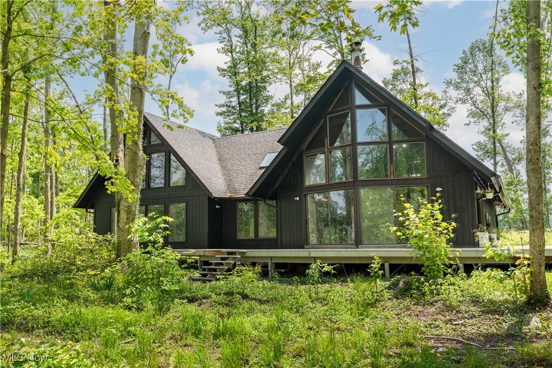 Welcome to this absolutely beautiful home all settled in this private treed almost 5 acre lot in Kinsman Twp. This home offers 4 bedrooms, 2.5 baths, 4000 sq ft of completely updated unique wooden A-frame. You are invited by the gorgeous wrap around porch and many large windows. Entering the home is the open concept, vaulted wooden ceilings. The kitchen has a huge island and cupboards with butcher block counters, stainless appliances, all new lighting, fixtures, backsplash, and so much more. Dining area looking over the treed front yard with wood burner fireplace and sliding glass door to the wrap around porch. Next to the kitchen is a full bath, built in book shelves and bedroom/office area. Above kitchen is winding staircase leading to the loft area and additional bedroom with balcony and large closets. The Great Room is off dining area with wood beams, Hardwood flooring through out home, fresh paint and high ceilings. The Great Room has another wood burning fireplace, sliding glass door to the small deck and partial fenced yard that overlooks the 3 car garage and treed backyard. This home has first floor laundry, completely updated full bath with walk in shower, linen closet, blue tooth speakers. The mudd room has a pet washing area. Heading up to the Master Bedroom on the second floor is an additional staircase with cedar shake walls for an extra unique touch. The enormous Master Bedroom has walk in closet, half bath and vaulted ceilings. There is one more additional bedroom or play area for the kids! So many updates include: New Septic 2024 with warranty, new paint, cleared trees, whole outside house painted, remodeled kitchen and bathrooms, New mini split heating and cooling, check updated sheet in supplements for more updates and utility info. Schedule your private showing today!