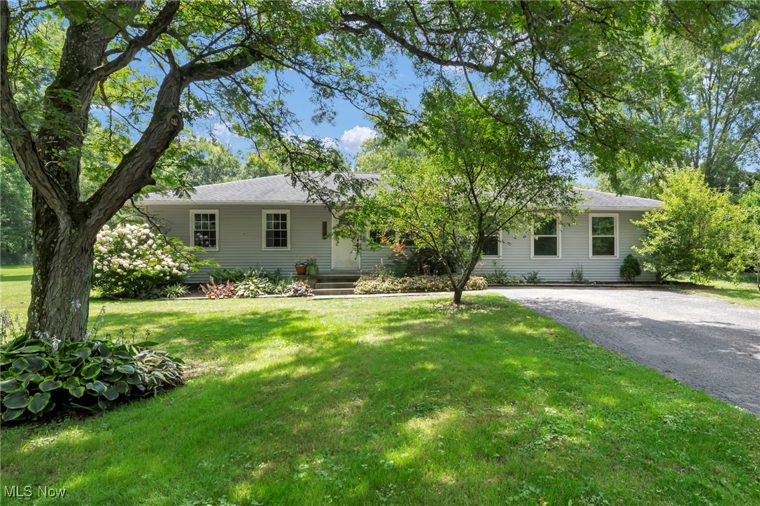 Welcome to 2264 Acre Rd in Akron – a private 1.5-acre retreat in the Copley-Fairlawn City School District. Tucked on a quiet street with only one neighbor, this well-maintained ranch offers first-floor living surrounded by mature trees, vibrant landscaping, and seasonal beauty from peach, nectarine, plum, and pear trees.
Inside, the open-concept layout features a bright dining room with bamboo floors, large windows, and a two-door coat closet, flowing into a kitchen with wraparound counters, bar seating, recessed lighting, pantry, and sliding doors to the back patio. The converted garage (2013) serves as a living room/home office with 8’9” ceilings, recessed lighting, and large windows, connecting to a private primary bedroom with half bath and laundry closet.
Three additional bedrooms have generous closets and bamboo flooring, while the full bath includes a double vanity, updated lighting (2025), and tile floors.
Outdoors, enjoy two raised garden beds with vegetables, herbs, and sunflowers, plus a large shed with attached deck. Updates include interior paint (2023), kitchen faucet (2025), bathroom lighting (2025), new well, pump, and water softener (2025), hot water tank (2019), central A/C (2021), and garbage disposal (2022).