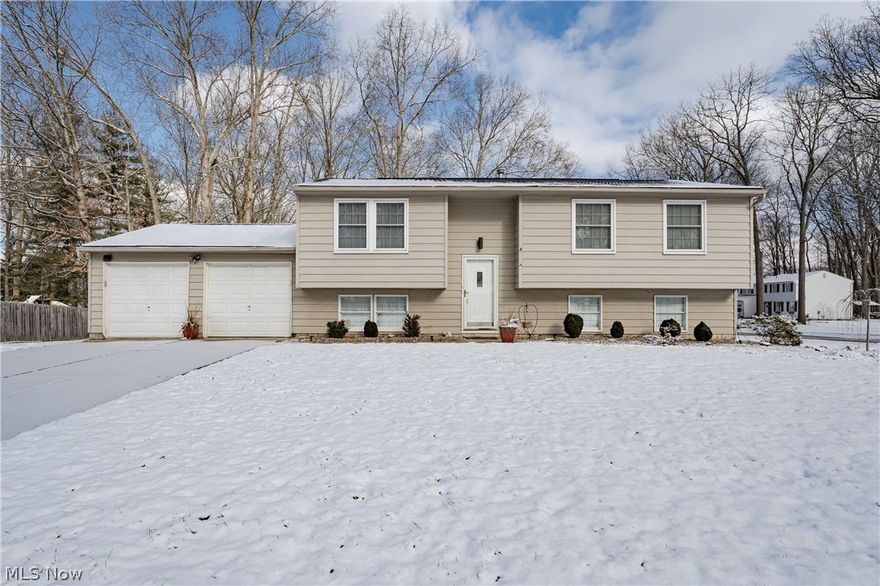 Great opportunity for an updated bi-level home in a park-like neighborhood of Stow! This lovely home features 4 bedrooms, 2 full bathrooms, spacious sun-filled living areas, and an expansive back yard with a patio and deck. The upper level boasts a renovated kitchen with granite countertops, a slate tile backsplash, a full complement of newer appliances, and a sunny eat-in area with a sliding door to the deck. The living room features updated LVT flooring that flows down the hallway and into 2 of the 3 upper-floor bedrooms. The third bedroom is the largest and has a big closet and carpeting. A full bathroom and linen closet complete the upper level. The lower level includes a massive family room with a gas fireplace, as well as a fourth bedroom with an ensuite full bath and an egress to the attached 2-car garage. Outside, there is a raised back deck, a fenced-in patio, a shed, and a deep back yard with a fire pit. Conveniently located just minutes from highway access, schools, and several shopping areas. Don't miss this one - it will go fast!