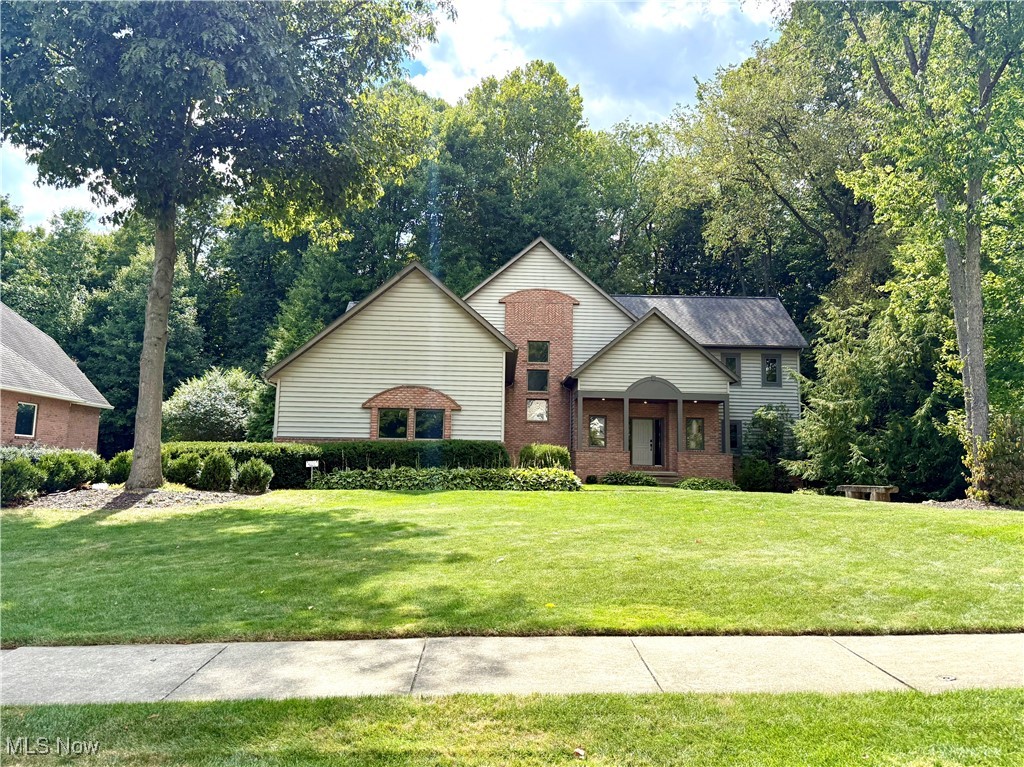 Experience the epitome of luxury living in this stunning residence, boasting nearly 5,000 square feet of meticulously finished space across three expansive levels. Nestled on a serene 0.91-acre lot, this home is enveloped by mature trees and lush foliage, providing an unparalleled sense of privacy. The main level welcomes you with a grand foyer that leads to a magnificent great room, featuring a cozy gas fireplace and a wall of windows that flood the space with natural light. The dining area seamlessly flows into a spacious kitchen adorned with elegant granite countertops and a central island, perfect for culinary enthusiasts. A delightful four-season room offers picturesque views of the backyard, while the surrounding deck invites you to enjoy the outdoors. Beautiful hardwood floors grace the majority of the main level, enhancing the home's sophisticated ambiance. Additionally, a laundry room and a versatile bedroom/office with a full bath complete this level. Head upstairs to find a breathtaking primary bedroom that boasts a vaulted ceiling and a charming window seat, creating a tranquil retreat. The attached luxurious bath is a true sanctuary, featuring a classic clawfoot tub, dual sinks, and a separate shower for your comfort and convenience. A guest bedroom and full bath on this floor ensure ample space for visitors. The walkout lower level is an entertainer's dream, showcasing a spacious rec room with a gas fireplace and kitchenette, perfect for hosting college gameday gatherings. This level also includes an additional bedroom, a full bath, and generous storage space. The backyard is a secluded oasis featuring a stone patio and outdoor kitchen, ideal for alfresco dining and relaxing after a long day. Situated in a sought-after neighborhood of finely appointed homes, this residence blends smart design with flexible living spaces perfectly suited to today's lifestyle.