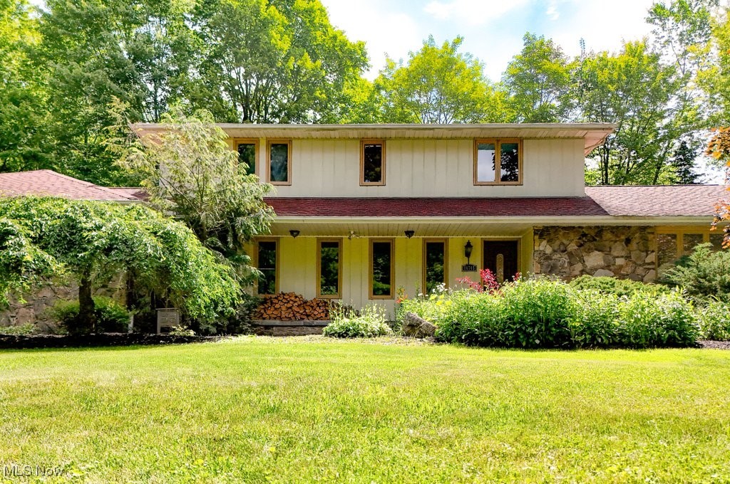 Tucked into the trees on a quiet, no-outlet street this lovingly maintained colonial is the kind of property that whispers “home” the moment you arrive. With 4.3 acres of open lawn, mature woods, and winding private trails, this home delivers space to breathe, room to roam, and endless potential for the life you’ve been dreaming about. Inside, the layout is generous and functional—designed for everyday comfort and easy connection. A large foyer welcomes you in, leading to an enormous living room filled with natural light. The kitchen is spacious and central, with easy access to the back deck and open sightlines into the cozy family room featuring handsome built ins and a wood stove insert that adds both charm and serious function. Picture quiet snow days with mugs of cocoa, the steady crackle of the fire warming the room—and the rest of the house too, thanks to its impressive heating power! Whether it’s everyday life or big gatherings, this space is made for togetherness and comfort.. A first-floor laundry and powder room add convenience, while the attached 2-car garage and the full unfinished basement provide plenty of space to expand or store all of lifes extras. Upstairs, you’ll find four bedrooms, including a large primary suite with a private full bath, and a roomy hall bath for the remaining 3 bedrooms. This home offers the rare opportunity to move right in and personalize at your own pace. Step outside and it’s easy to imagine morning coffee on the deck, afternoon hikes in your own backyard woods, or twilight bonfires under the stars. Notable improvements: furnace and AC 3years old, 50 year architectural shingle installed 10 years ago, HWT 5 years, chimney crown and tuck pointing on chimney 2025, and newer Kinetico system. Whether you're craving privacy, a connection to nature, or simply a quiet place to call home, you have found all three here! Just 6 miles from downtown Chagrin Falls and under 10 minutes to I-271— you are tucked away, but never too far.