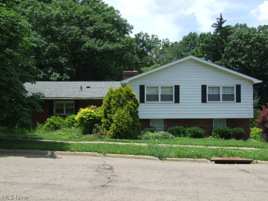 Great 4-level split with large rooms and fantastic views.  First floor has nice size living room and step-up dining room, both with hardwood floor and large picture windows overlooking the hills and trees of Sand Run Park.  Super kitchen is the length of both the Living Room and Dining room, giving you tons of cupboards and counters with eating area.  Upper level has 4 big bedrooms and two full bathrooms, including the master bathroom.  Lower level has a huge family room with fireplace and slider to sunroom, overlooking the park again.  This level also walks out to the attached 2-car garage.  Final lower level includes half bath and rec room with built-ins including bar area, hot tub (not sure if it works) and sliders to the patio and rolling backyard.  A few loving touches and this could be a wonderful Home.