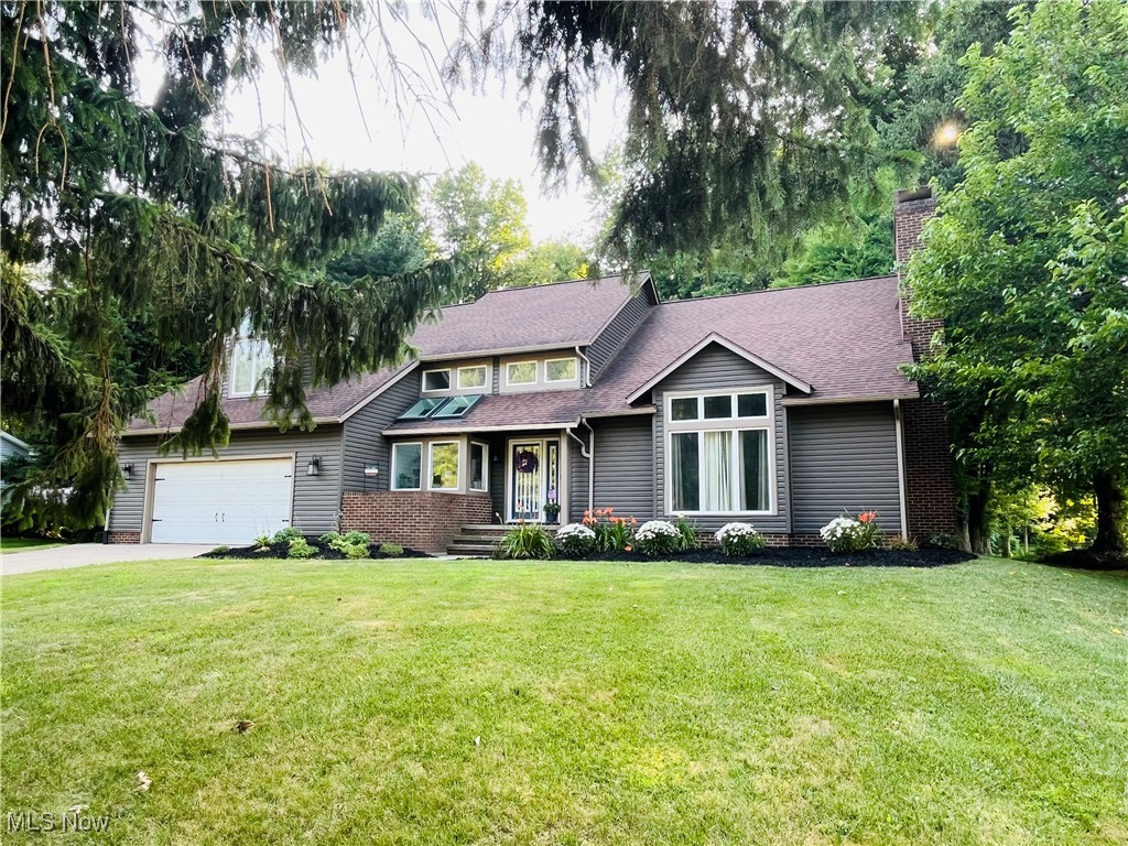 Welcome home to the alluring architecture found in this understated stunner. On almost a half acre and backing up to the Madison Country Club golf course, this 4 bedroom Contemporary colonial offers unique features and masterfully engineered character. Rich in dramatics, the two-story entry foyer and great room hold a captivating half cathedral ceiling, rising to the nearly full-length cat-walk terrace overlooking the entire space. Floor to ceiling stone mantle in this great room houses a working gas fireplace. A proper dining room is well-placed off the kitchen, yet remains open to the great room - a comfortable space to entertain. The chef's kitchen is an open concept space with an eat-in area, kitchen island with room for stools, and broad granite counters. Detailed w marquee quality and craftsmanship. Deep stainless sink, and an industrial faucet. Cherry cabinets with soft close feature. Hickory flooring in kitchen and family room - both of which benefit from large windows and natural light coming n from the west. A working wet bar in the adjacent would-be family lounge makes a 'neat' sitting room for a friendly chat and cocktail. Upstairs you'll first encounter the Owner's suite, with views to both the back and front yards, taking account of the sizable bonus area. Could easily make for a reading library, a fitness studio, home office, or nursery. Then on to the double vanity and broad counters of the en suite, with his and hers walk-in closets. Three more bedrooms down the hall, as well as a common full bath. 2.5 car garage with built-in workshop bench and gas heater. Well cared for; many updates in recent years including roof, vinyl siding, AC unit, boiler replaced, bathrooms and lighting updated, as well as 80% of the interior painted in the past two years. Garden boxes and a 10' x 14' shed flank a large suburban backyard, nestled against the wood line of golf course property. Close to shopping, grocery, golf, parks, retail, restaurants, and Lake Erie.