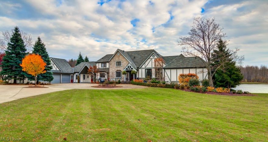 Welcome home to this magnificent Casual English Tudor Estate. Situated on 6.55 acres, the grounds features a 2 acre lake with beach area, a bridge that leads to a private island, a five stall horse barn, and a 10,000 sq feet award winning indoor riding arena with 14 ft. high ceiling. Come experience the privacy of this country estate. Inside this magnificent home the updates abound. Over 5,200 sq feet of living space. Remodeled gourmet kitchen with stainless steel appliances, double oven with gas cooktop range. Dining room and lounge area feature pegged oak floors and cedar beams. The great room with craft built Alder wood feature wall, highlighted by custom cabinets, bookcase, crown molding, gas fireplace w/limestone and granite hearth.  Elegant remodeled master bedroom and master bathroom – double sinks, granite, and walk-in limestone shower, w/skylight. Finished walk-out lower level with bedroom and full bathroom. 3+ car garage with cedar walls and an upstairs for ample storage, a b