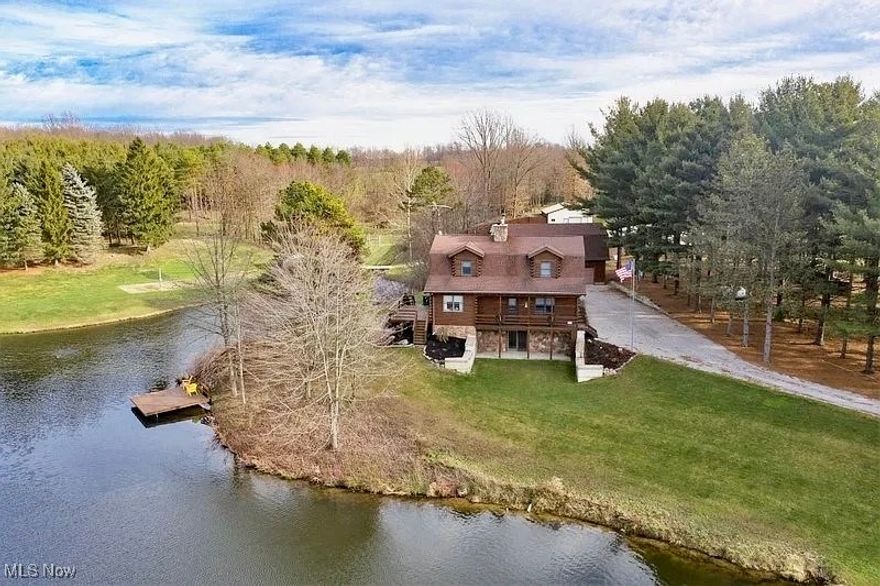 High-quality custom log cabin nestled amongst 12 gorgeous acres that includes private 2-acre lake, rolling hills, mature trees, multiple pole barns, and enclosures. From the moment you enter the winding driveway, you'll be sure to enjoy the secluded nature of your oasis Inside the cabin, a spacious kitchen and two-story great room are complimented by a fireplace w/stunning stone surround. Spectacular views from every room! Large deck connects the dining area and the kitchen's 4-seat island, while overlooking the lake.Main level has a bedroom, full bathroom, and sizeable laundry & storage room. Upstairs offers nice loft areas and an oversized owner's suite with walk-in closet, and master bath.Walk-out basement has an open living room and attached rec area with additional storage room; beautiful large sliding doors give direct access to lake and covered patio. Incredible outbuildings including; 3 car garage w/loft/ 2000 sq ft pole barn/1200 sq ft horse barn w/3 stalls/ fenced in pasture. New shingles installed on house roof 6/20/25