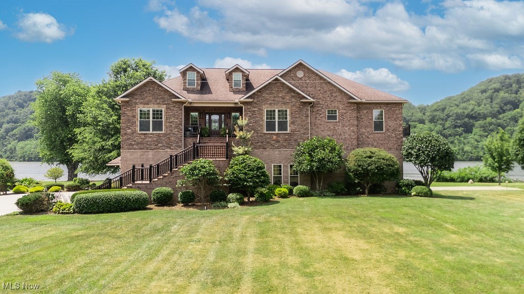 Riverfront luxury at its finest! This stunning all-brick custom home is perfectly positioned on 2.61+/- acres with approximately 300 feet of direct Ohio River frontage in St. Marys, WV. From sunrise coffee to sunset fireside chats, river life surrounds you here. Take in sweeping River views from nearly every room or step outside to fully immerse yourself in the beauty of the Ohio River. Enjoy mornings on the deck just off the master bedroom, spend the day fishing or relaxing by the water, then gather under the 35x21 covered pavilion with cozy fireplace as the sun sets over the water. Whether you're hosting guests or enjoying a quiet moment alone, this property was designed to celebrate the river from every angle. Step inside and you’ll find an airy, open floor plan with light-filled spaces, rich hardwood flooring, and a gourmet kitchen featuring gorgeous wood and white cabinetry, massive island, new subway tiled backsplash and granite counters. The 23x21 master bedroom offers a peaceful retreat, complete with an en suite bathroom with double sinks, tiled flooring, and stylish tiled backsplash. Thoughtfully designed for both function and comfort, it provides a clean, modern feel. Additionally, the space features a 12x12 walk-in closet with built-ins and direct access to a 12x9 dream laundry room filled with cabinetry and a sink. The home is fully wheelchair accessible with an elevator and an updated second full bath with roll-in shower. The garage level is equally impressive—offering radiant heated floors, a half bath, space for up to 5 vehicles, and the flexibility to use it as an entertainment area. A whole-house Generac generator ensures you’re always prepared. Multiple outdoor living spaces, including upper decks and a stunning ground-level covered patio create seamless indoor-outdoor living and offer panoramic views of your private stretch of the river. Don’t miss this rare opportunity to own a piece of Ohio River paradise—where every day feels like a vacation.