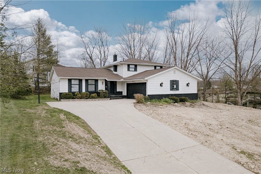 Located in a quiet, sought-after neighborhood in Solon, 5880 Deepwood Trail offers spacious living areas, an inviting layout, and exceptional flexibility for everyday living and entertaining. The front door opens into a welcoming foyer with tile flooring and a curved staircase that creates an impressive first impression. The foyer flows into a spacious living room featuring a vaulted ceiling, abundant natural light, and updated LVP flooring that continues into the adjacent formal dining room. The kitchen offers granite countertops, ample cabinet space, included appliances, and a bright eat-in area with a bay window overlooking the yard. Just steps down from the kitchen is an expansive family room designed for gathering and entertaining. This inviting space features a brick accent wall with fireplace, sliding door access to the back patio, and a wet bar. Off the family room is a convenient first-floor bedroom, full bathroom, and laundry/mud room with direct access to the attached two-car garage. Upstairs, the home includes three spacious bedrooms and two full bathrooms. The oversized primary suite offers a large bedroom and an ensuite bath with a tiled step-in shower. A second full bathroom completes the upper level. The partial basement adds additional living space with a large L-shaped recreation room along with a separate storage and utility area. Outside, the patio provides a comfortable setting for relaxing or entertaining, while the substantial side yard offers additional outdoor space to enjoy. Major exterior improvements include a new roof, new siding, and new garage doors scheduled for installation, with the buyer having the opportunity to choose the final selections. Make this your home today!