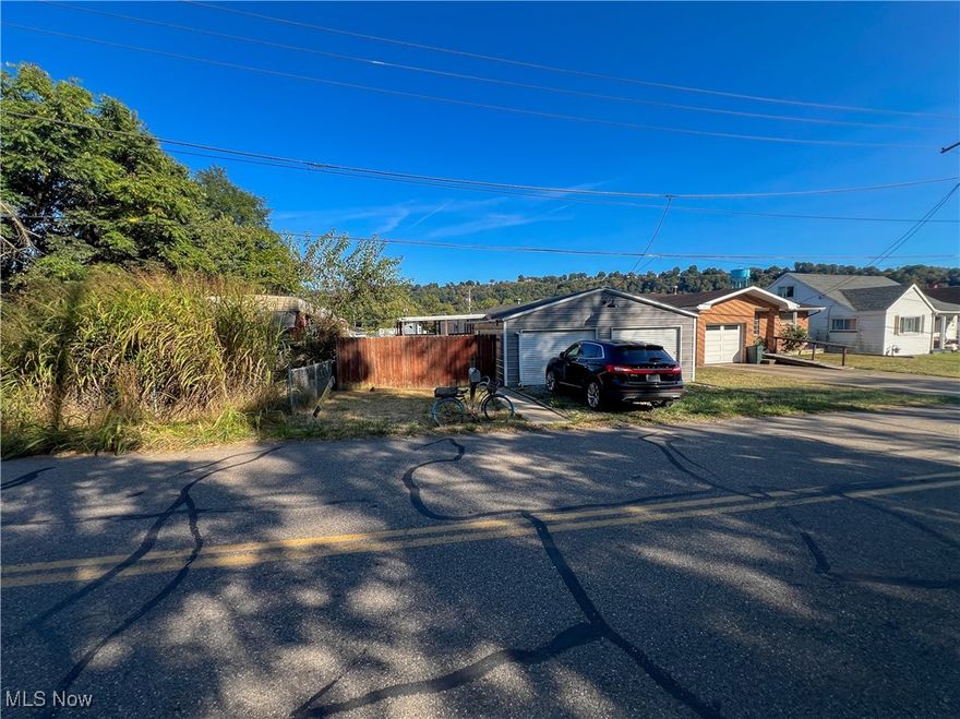 HUD Home selling AS-IS. Two bedrooms, two full bathrooms, first-floor laundry, living room, kitchen, large covered deck, and a detached two-car garage.