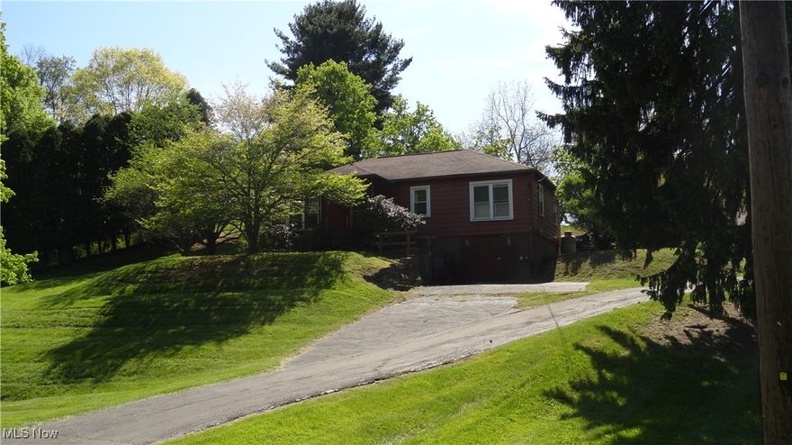 Quaint ranch home in the country with 2 car detached garage, paved driveway.  3 bedrooms with hardwood floors.  Nice sized living room with hardwood under the carpet, eat-in kitchen, large covered deck off kitchen with ramp to driveway.   Large rec room in basement, plus an additional kitchen.  Walk out to the large workshop with its own entry door from driveway.  5+ acre lot with yard and trees in the back.  Extra detached shed for workshop or equipment storage.