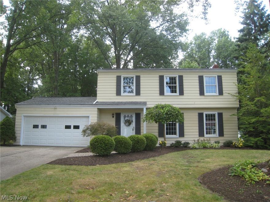 As you pull up, you will notice the professionally landscaped yard with manicured beds of blooming perennials that surround the home and property.  The foyer entry welcomes you with recently installed muted gray subway tiles. The updated half bath is conveniently located here. To the right is the formal living room enhanced with beautiful hardwood floors that flow throughout the entire home and white crown molding and wood trim.  All the newer windows have custom shades and white trim, too.  The dining room is open to the spacious kitchen with an island, upgraded appliances and custom cabinetry.  The double pocket doors can close off the dining room for a more formal dinner and a paned glass door to the outside cobblestone patios and composite deck.  The wall between the kitchen and family room is opened up and creates a great entertainment or family space across the rear of the house.  An addition was added with a possible 5th bedroom or office and full bath with step in double shower