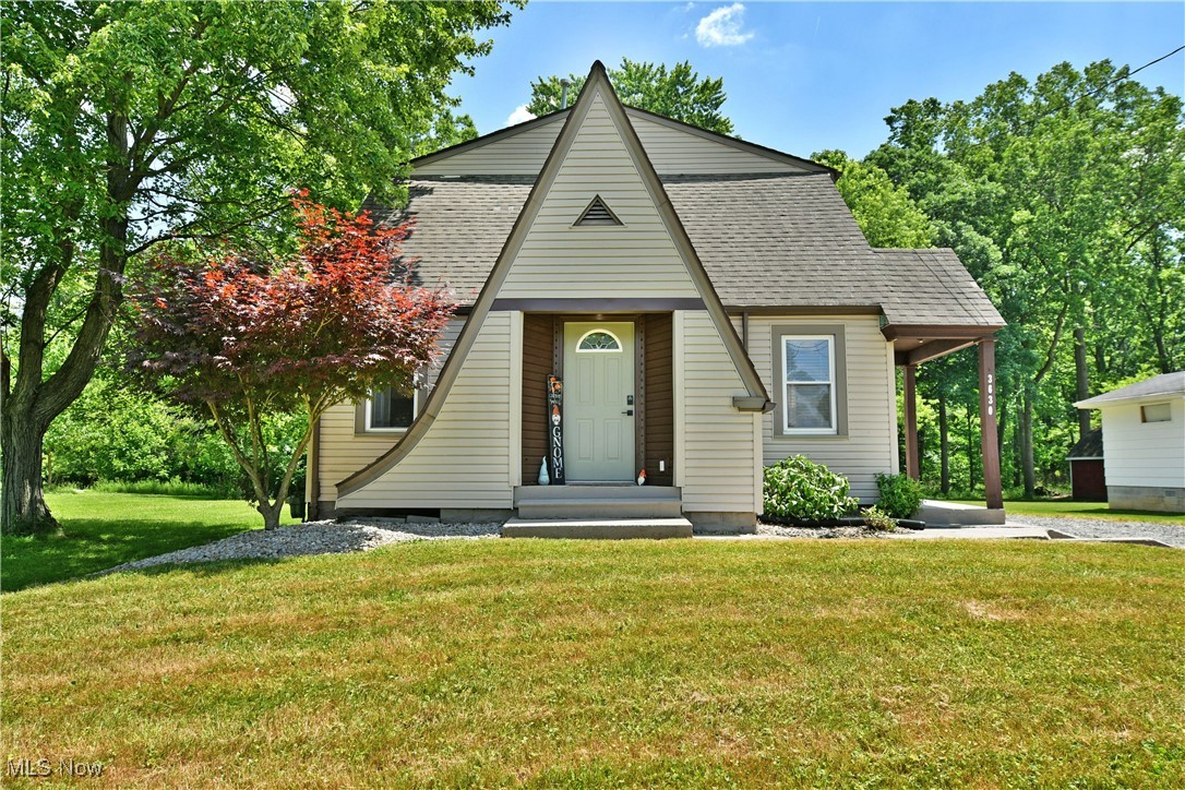 Storybook charm with Pintrest-perfect good looks, this lovely Champion home is ready to make all your dreams come true! Standing out like no other, this must-see residence offers unique curb appeal as it presents its aggressively sloped roofline that frames the recessed entryway while a covered side entrance makes every day egress a breeze. The gravel drive extends out to find a raised rear deck that peers out across the grassy yard. Near the tree line, a bonus storage shed accompanies a play area. Step inside to find a stained wood trimmed staircase as hardwood styled flooring runs underfoot. A short hall breaks away to find a moody half bath with its repurposed and rustic, raised basin vanity paired with the elaborately tiled floor. Next door, first floor laundry service keeps things clean and easy. Meanwhile, the impressive living room extends into a great room style layout as the bold colors showcase its electric fireplace. Decorative lighting hangs overhead as it continues into the potential dining area. The remarkable kitchen stops the show with its prominent center island offering its own bar top seating while chevron patterned countertops run beneath the ceramic and shelf lined backsplash. A farm basin sink awaits in front of a shelf window. Upstairs, three engaging bedrooms provide unique colorways, overhead sky lights and individual style as they join an equally impressive full bath. Call today to be first through the door!