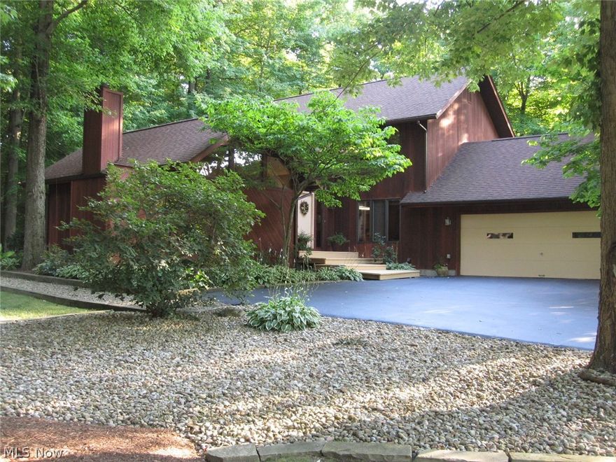 Make your new home in this beautifully maintained, custom built 4 bedroom 2.5 bath home on a well manicured and landscaped, private wooded setting. This all redwood home in excellent condition includes an extra large chef's kitchen with solid cherry hardwood flooring, commercial 60" Garland gas stove and large center island with plenty of cabinets. The living room with vaulted ceiling and fireplace is accented with plenty of outdoor light from large Pella windows. There is also a convenient first floor laundry leading out to the attached 2.5 car garage. All the bathrooms have been updated as well as a new 200 amp electric service. The home has all Pella windows that allow for plenty of natural sunlight. Enjoy the included hot tub on the very private rear deck. Also included is a vintage billiard table from the historic Todd hotel in Youngstown and a wine cellar in basement. Motivated seller see Broker Remarks.