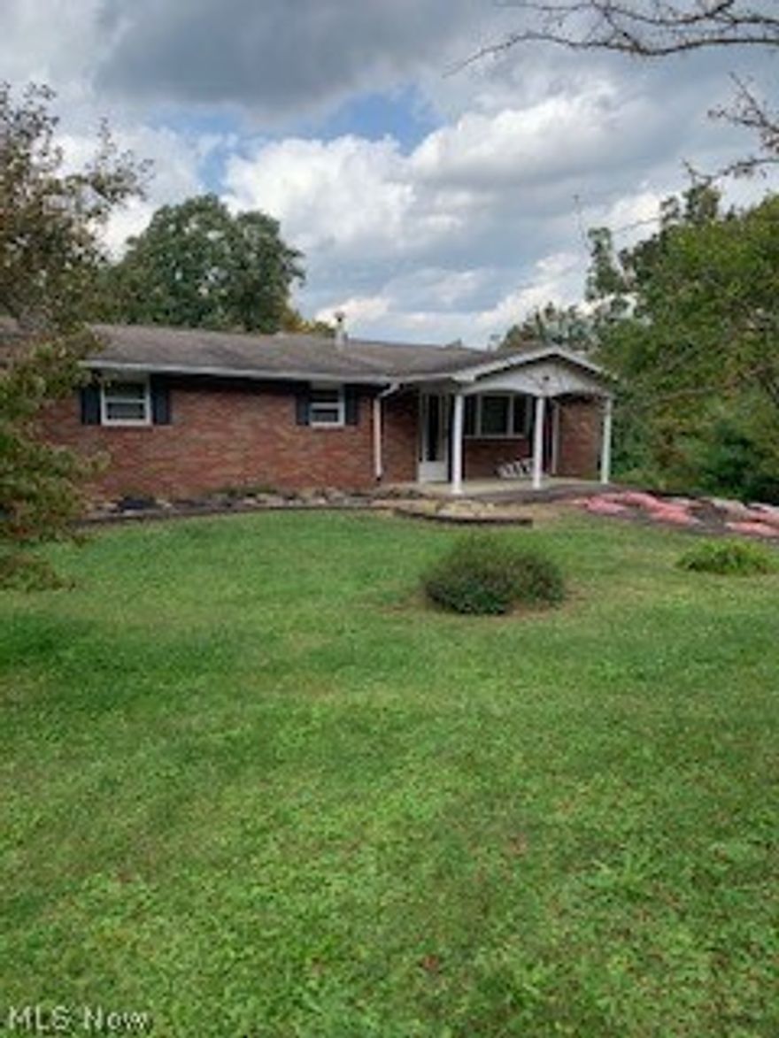 Just minutes from town, this nice brick ranch offers country living with an open floorplan.  Insulated windows, newer carpet and ceramic tile throughout, updated bath in basement, updated electrical service, and a large 14x36 deck off the kitchen overlooks the lovely wooded, rolling backyard. A circular driveway around the back of the house affords entry into the garage or the carport with immediate access to the family room.  The family room is equipped with a summer kitchen, full bath and a closet which could easily be used as a mother-in law suite.  A few minor exterior maintenance repairs are needed but seller is unable to do any repairs. The owner has never used the fireplaces and has them blocked off.  Don't miss your opportunity to own this wonderful home.