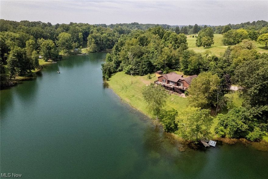 BREATHTAKING VIEWS on lake front property near golf course create the PERFECT GETAWAY to call home!  Enjoy your morning coffee from your oversized deck overlooking the water.  This secluded 5 Bedroom, 3 Bath home is situated on almost 4 acres and offers a private dock for fishing or boat launching.  Open concept floor plan with abundant natural lighting and windows with amazing views of Wilson Lake. Classic ranch style home offers one floor living, plus a  BONUS lower level - complete with two family rooms, kitchenette, laundry and two additional bedrooms - - all with walk-out access to the lower level private paver patio!  Eat-in kitchen features granite counters, stainless steel appliances and a laundry closet!  Property backs against the Switzerland of Ohio Golf Course. Call today to schedule your private tour!