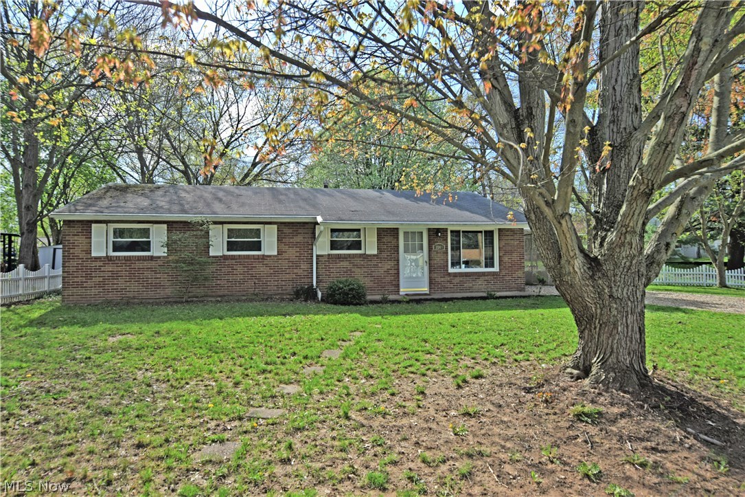 This sharp looking brick ranch makes the most out of its lot, with stunning colors from the surrounding trees and it’s wrapping white picket fence that invites you towards the home. Inside, a spacious living room boasts traditional ranch style with a wide-open floor plan that spills into a dining area. Brand new carpeted flooring makes way for a tiled entry way. The kitchen, with appliances staying, makes for a cornerstone as cabinets tower above the new counters and stainless sink fixture. Laundry, with washer and dryer staying, is located nearby along with entries to both the back patio and a full bath that splits the main hall. An additional full bath resides before the bedrooms, with brightly lit, updated vanity and vinyl tile flooring. The adjacent master bedroom also has shared private access. Two remaining rooms each offer carpeted flooring and comfortable living space along with ample closets. The backyard is also fenced in and includes a storage shed. An attached carport is gr