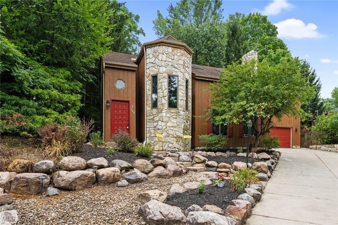 Welcome to 163 Burns Rd! A warm and spacious home offering both character and comfort. From the moment you arrive, you'll be greeted by eye-catching curb appeal with a unique mix of warm wood panels and natural stone, creating a rustic yet refined exterior. Step inside to a bright, open floor plan with soaring lofted ceilings that enhance the airy feel throughout. The family room is ideal for everyday living, with sliding doors leading to the back deck for seamless indoor-outdoor flow. The living room is equally inviting, featuring large windows, a striking geometric stained-glass accent, a lofted ceiling, and a cozy stone fireplace. The kitchen boasts ample cabinetry, a breakfast bar, skylights that flood the space with natural light, and stainless steel appliances—all included. Just off the kitchen, you’ll find a full bath and a convenient laundry room. Upstairs, a bright bonus room makes a perfect home office or TV space. The spacious owner’s suite features a lofted ceiling, two closets, and an en-suite bath with a soaking tub. Two additional bedrooms and another full bath complete this level. The finished lower level provides even more living space, with a large rec room for movie or game nights and plenty of storage. Outside, enjoy your private backyard retreat: a deck for summer barbecues or morning coffee and a deep, tree-lined yard that offers a peaceful, park-like setting. A shed and an attached 2.5-car garage add everyday convenience. Recent updates include: remodeled first-floor bath, updated laundry room, new refrigerator, microwave, sink, and dishwasher (2025), new stove (2024), and furnace (2021). Ideally located near the scenic Black River Reservation, with shopping, dining, and highway access just minutes away. Don’t miss your chance to own this beautifully maintained, move-in ready home—schedule your private showing today!